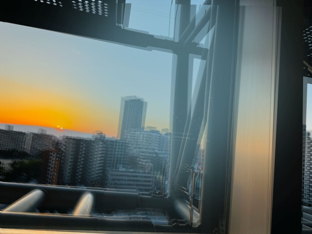 ビルから覗く夕日が二重にブレる